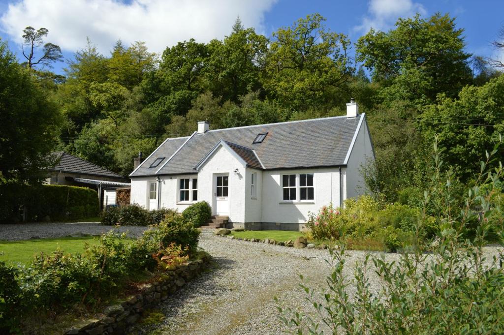 a white house with a gravel driveway at Teal Cottage in Clachan of Glendaruel