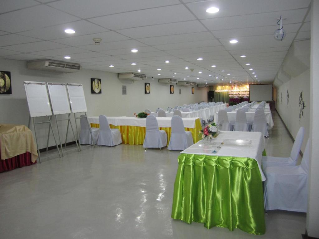 A large, brightly lit banquet room prepared with long rows of tables.