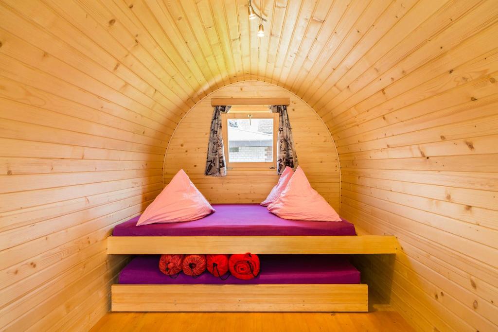 a small room with a bed in a wooden cabin at Camping Lazy Rancho - Eiger - Mönch - Jungfrau - Interlaken in Interlaken