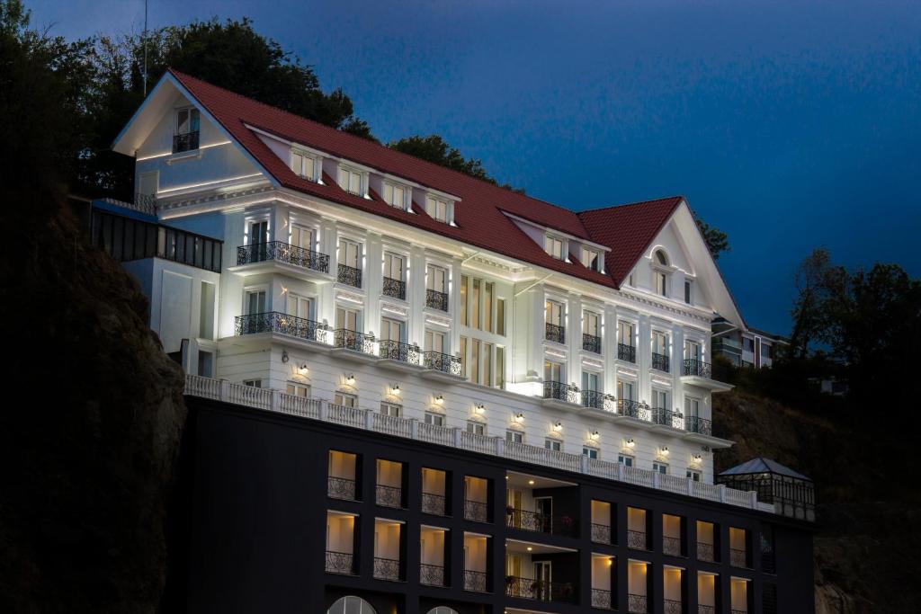 a large white building with a red roof at Mell Hotel in Trabzon