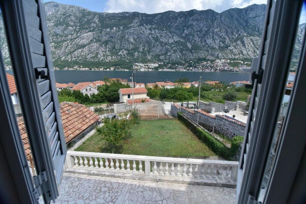an open window with a view of a city and mountains at Garden Vista Stone House in Kotor