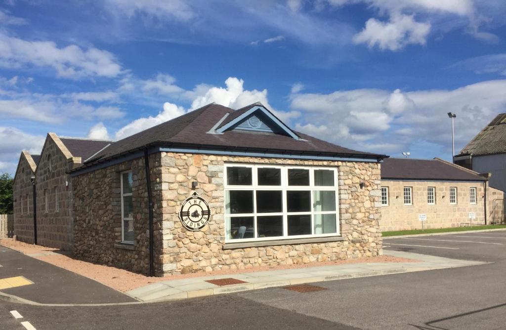 un edificio de piedra al lado de una calle en The Sidings Inverurie, en Inverurie