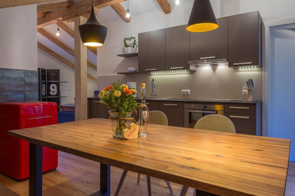 a kitchen with a wooden table with flowers on it at Alpen Appartement BelEtage in Mayrhofen