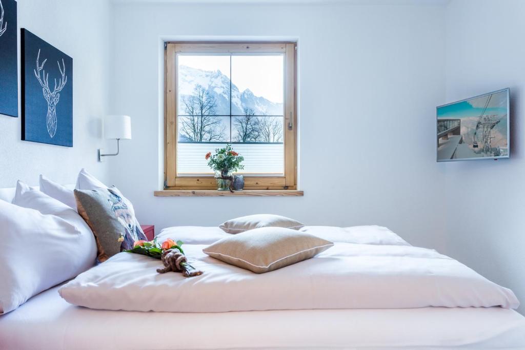 a white bed in a room with a window at Alpen Appartement BelEtage in Mayrhofen