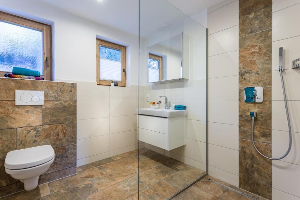 a bathroom with a toilet and a glass shower at Alpen Appartement BelEtage in Mayrhofen