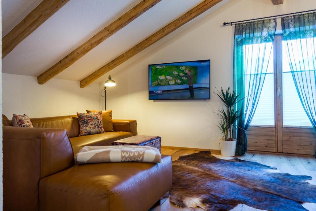 a living room with a couch and a tv at Alpen Appartement BelEtage in Mayrhofen