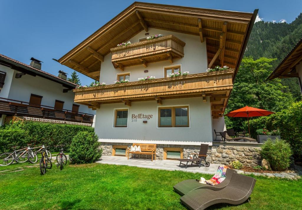 a large house with a balcony on top of a yard at Alpen Appartement BelEtage in Mayrhofen