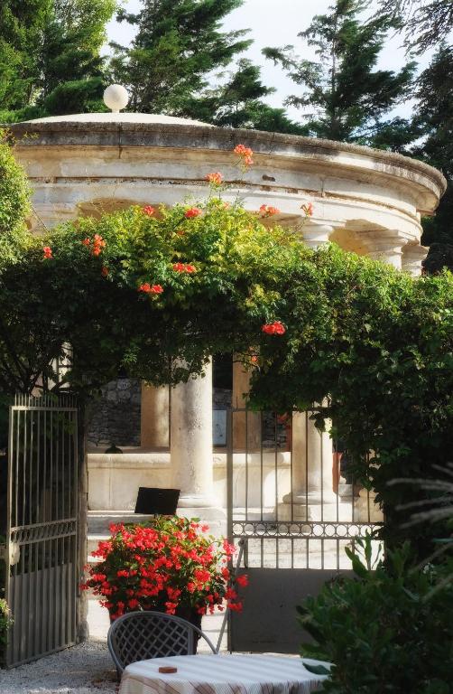 un edificio con un ramo de flores en una valla en Le Clair de la Plume - Teritoria, en Grignan