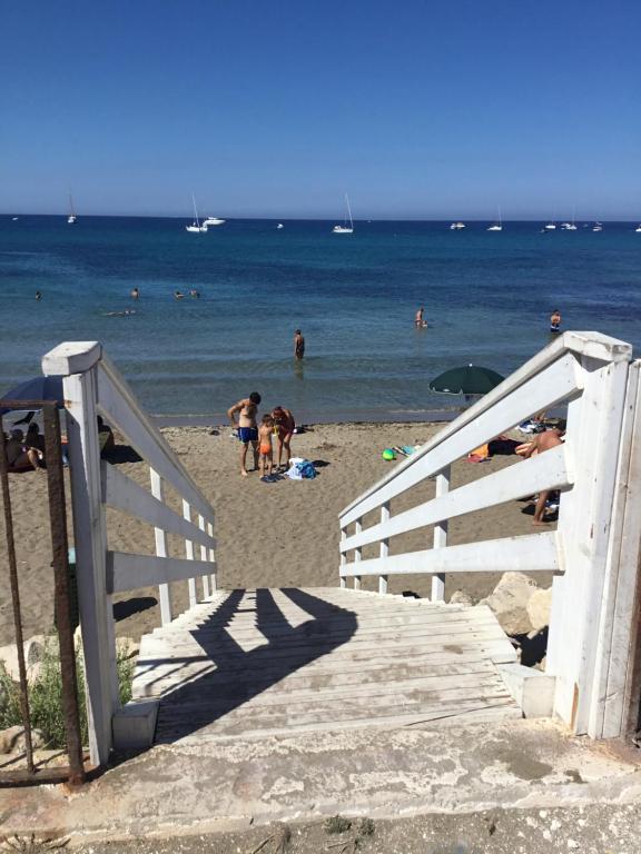 eine Gruppe von Menschen am Strand mit dem Meer in der Unterkunft Hotel Vittorio in Portopalo