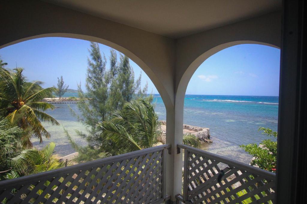 a room with a balcony with a view of the ocean at Sahara Hostel in Montego Bay