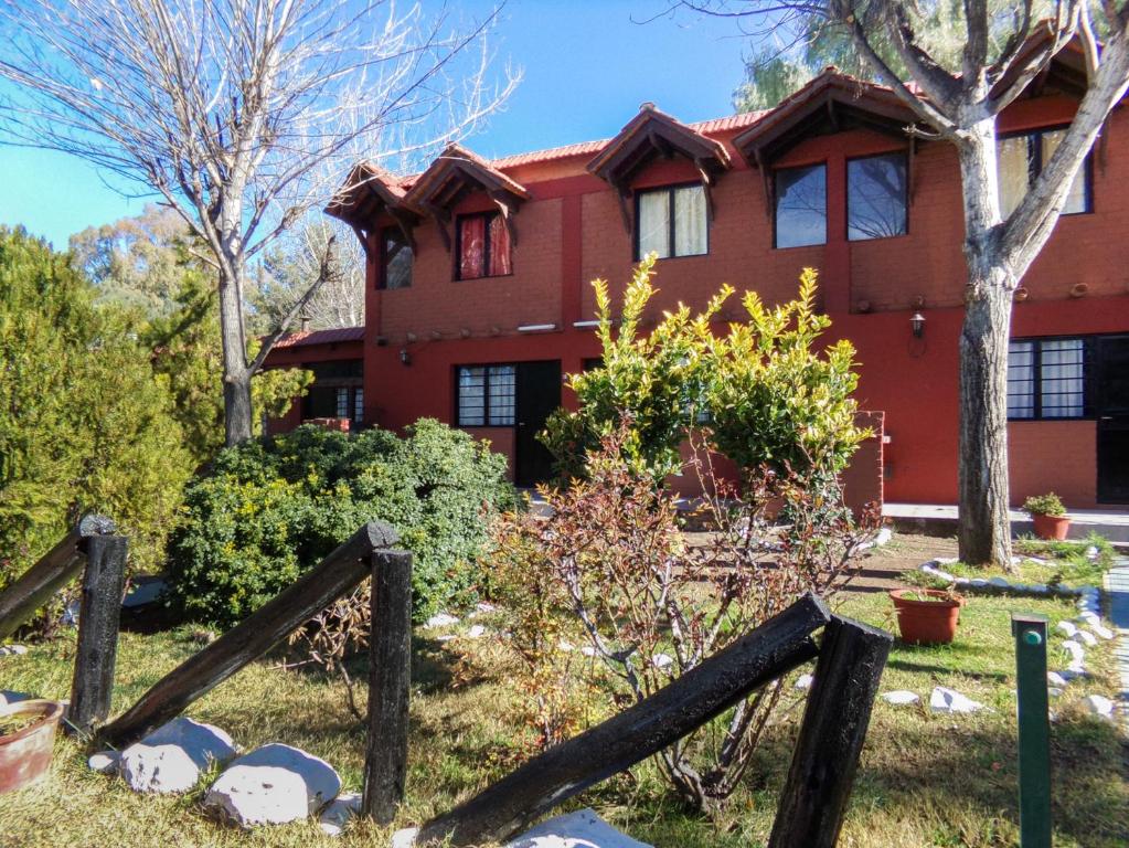 een rood huis met een houten hek ervoor bij Cabañas El Challao in Mendoza