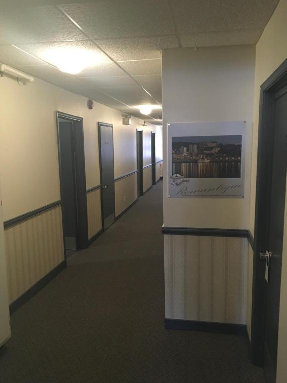 an empty hallway of an office building with a picture on the wall at Auberge Centre Ville in Saguenay