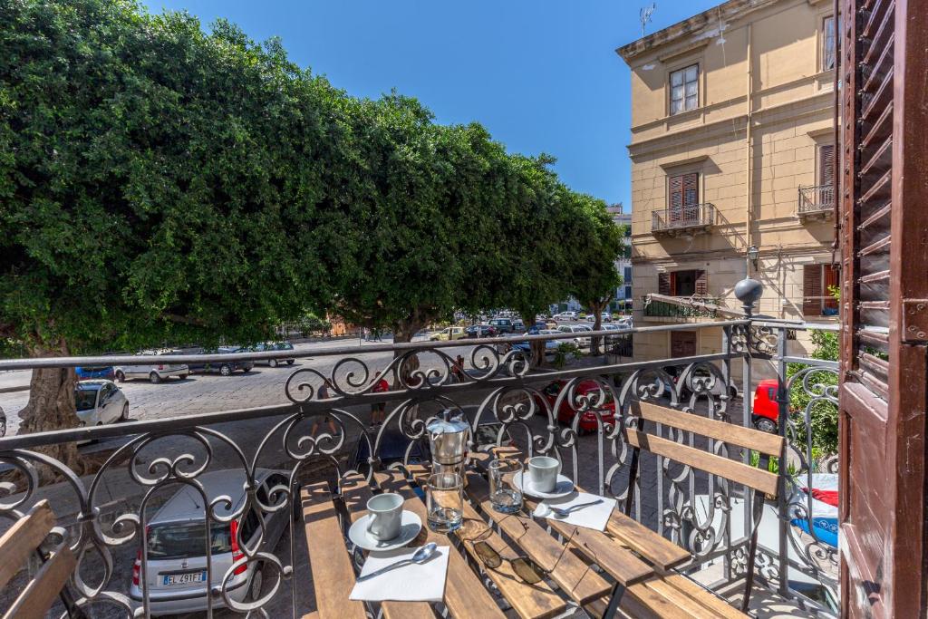 a balcony with tables and chairs on a city street at Loft Piazza Marina by DomuSicily in Palermo
