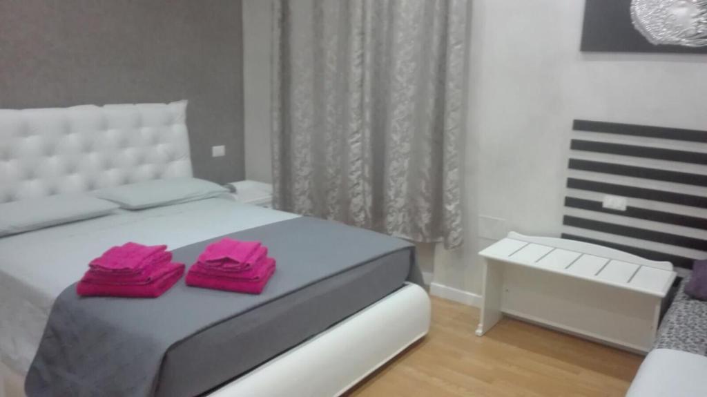 クロトーネにあるDonna Margharetのベッドルーム1室(ピンクのタオルが付いたベッド1台付)