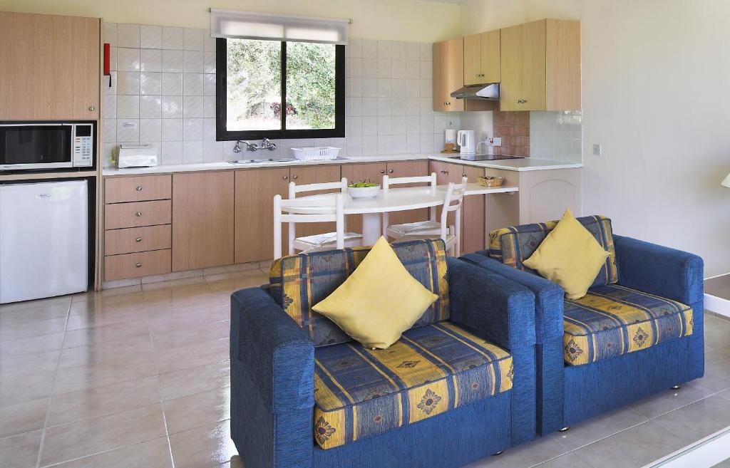 a kitchen with two blue chairs and a table in it at Club Aphrodite in Erimi