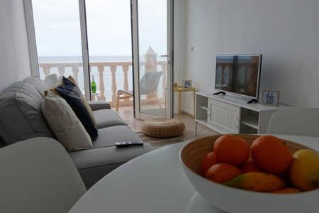 a living room with a bowl of fruit on a table at Apartamentos Rocamar el Medano in El Médano