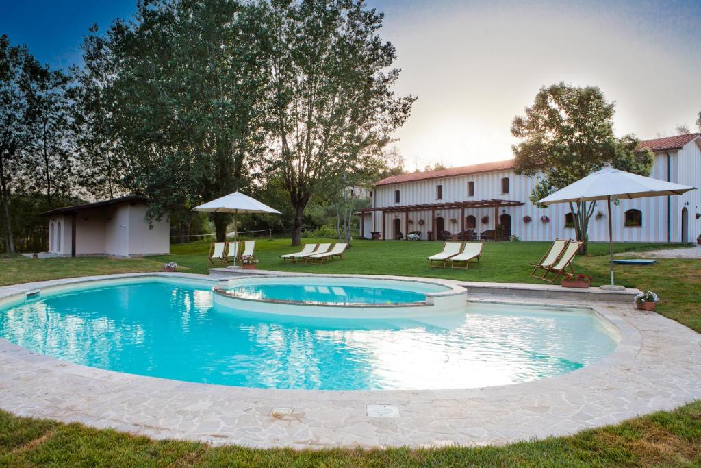 a pool with chairs and umbrellas in a yard at Agriturismo La Pesca in Broccostella