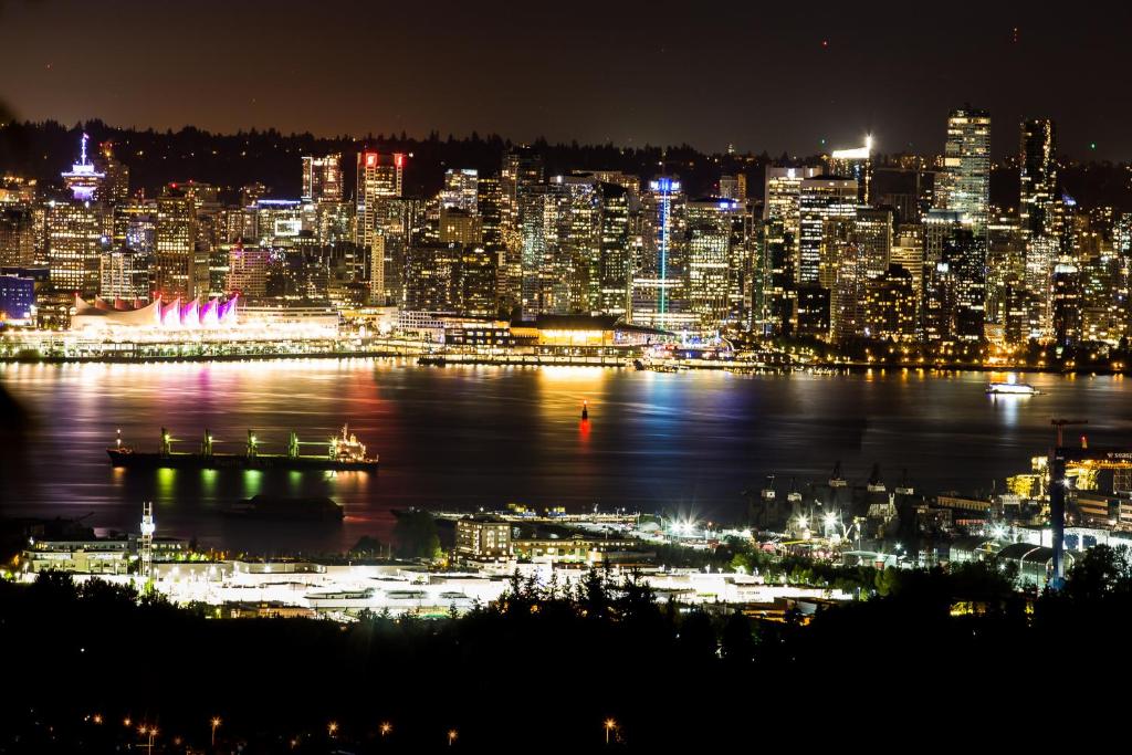 a view of a city at night with a city at Emperial Suites in North Vancouver