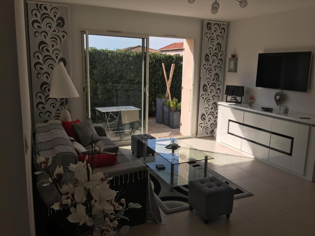 a living room with a couch and a table at Les Lones avec jardin in Six-Fours-les-Plages