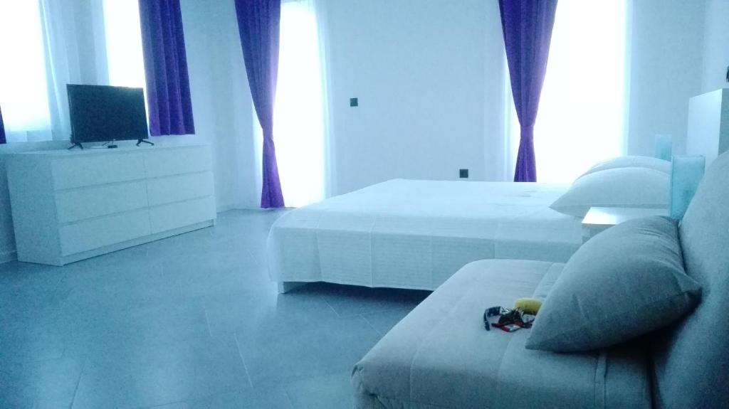 sypialnia z 2 łóżkami, kanapą i telewizorem w obiekcie Hrvoje w mieście Pag