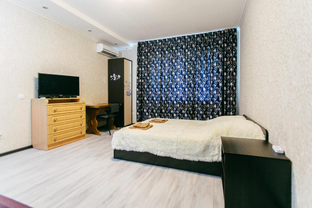 タンボフにあるApartment PrezentHaus Michurinskaya 24のベッドルーム(ベッド1台、ドレッサー、テレビ付)