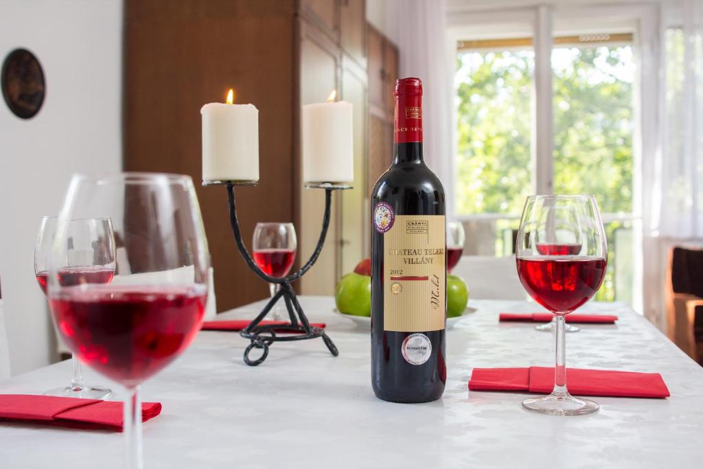 - une bouteille de vin rouge assise sur une table avec deux verres dans l'établissement Andrássy Apartment with Inside Parking, à Budapest