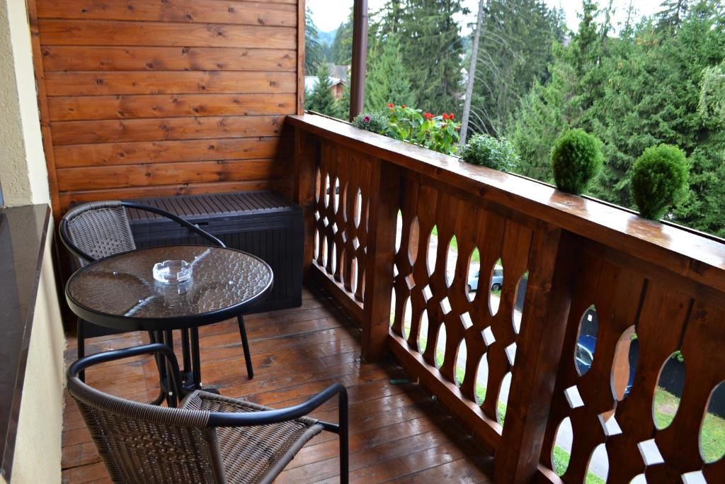 einen Balkon mit 2 Stühlen, einem Tisch und einem Fenster in der Unterkunft Studio Alex in Poiana Brașov