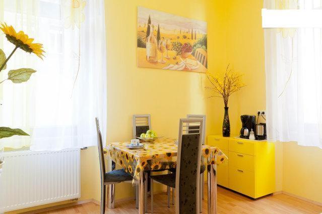 uma sala de jantar com uma mesa e uma parede amarela em City Apartment in Nürnberg em Nuremberga