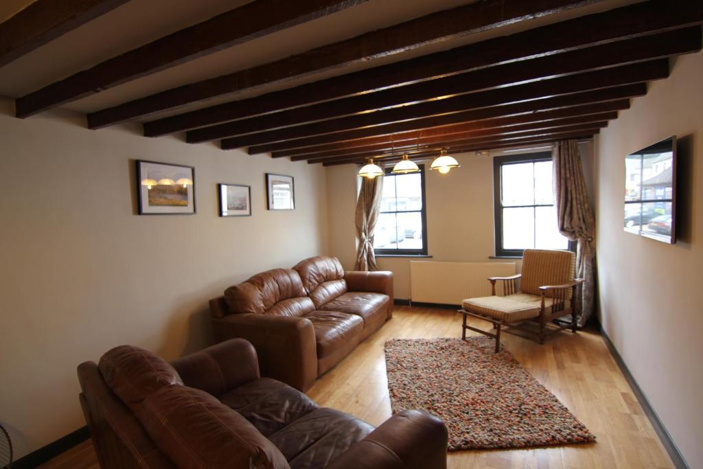 a living room with leather couches and a table at The Warehouse in Ulverston