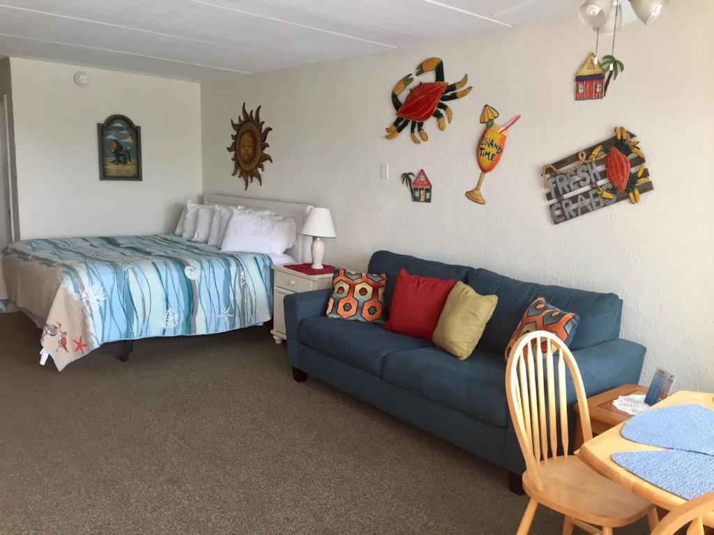 a bedroom with a blue couch and a bed at Lollipop Motel in North Wildwood