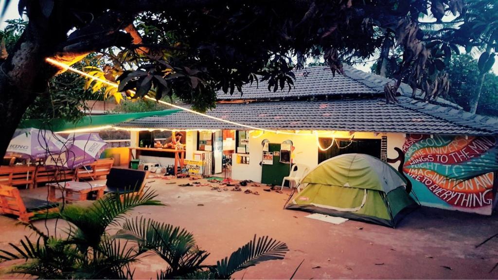 a green tent in front of a house at Happy Panda Hostel Arambol Goa in Arambol