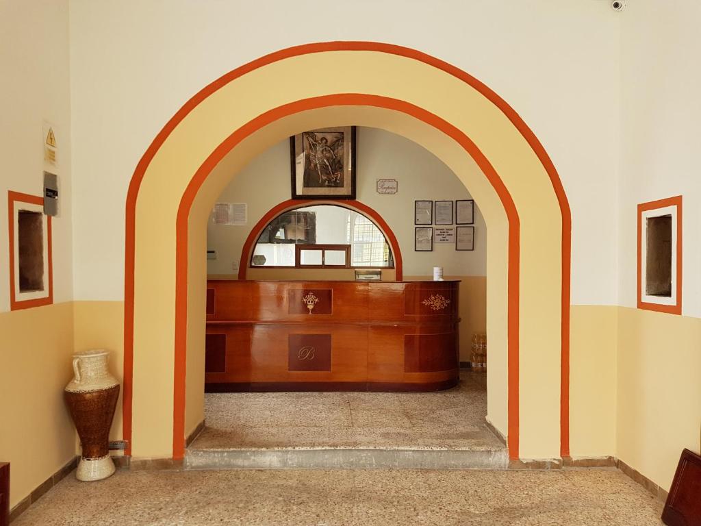 um arco num quarto com uma secretária de madeira em Hostal Buenos Aires em Quito