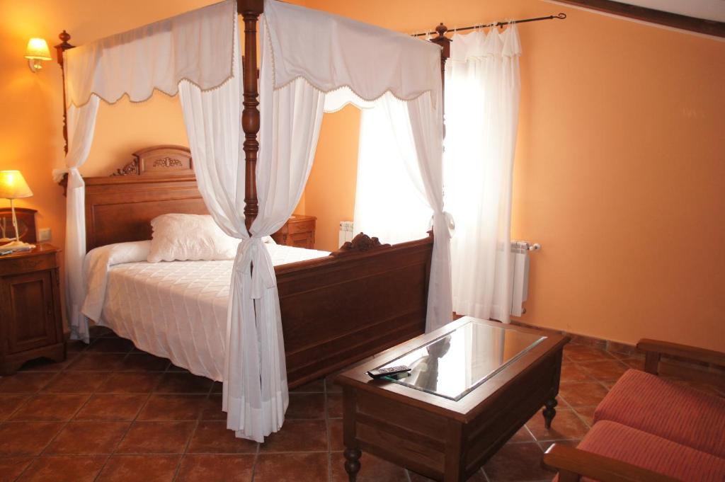 a bedroom with a canopy bed with a window at Casa Rural Blas in Brihuega