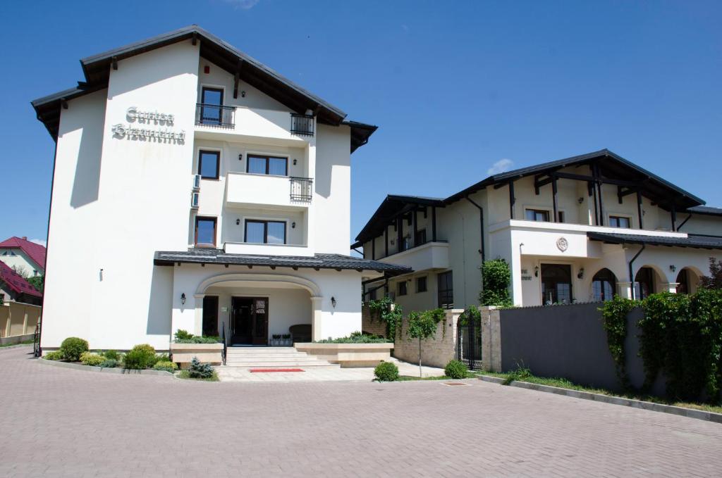 a large white building next to a driveway at Curtea Bizantina in Suceava