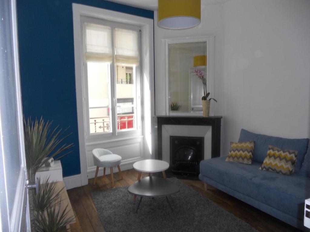 a living room with a blue couch and a fireplace at au 303 in Lyon