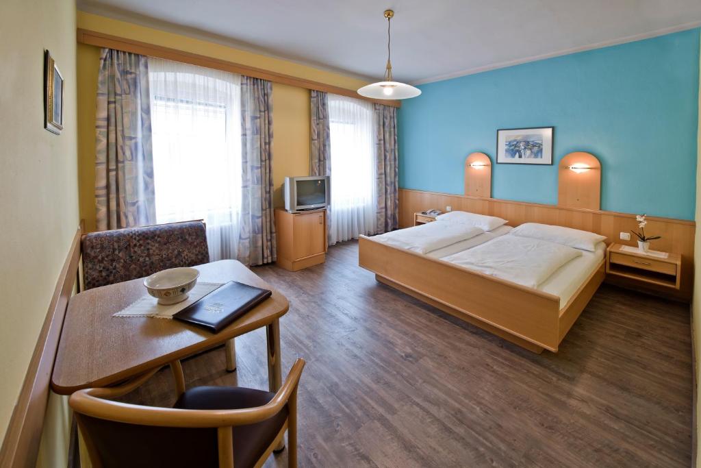 une chambre d'hôtel avec un lit et une table dans l'établissement Pension Martha, à Grein