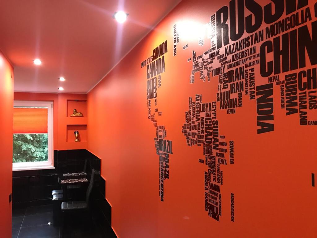 una sala de estar con una pared de color naranja con escritura. en Trumpalaikė buto nuoma Rokiškyje su jacuzzi, en Rokiškis
