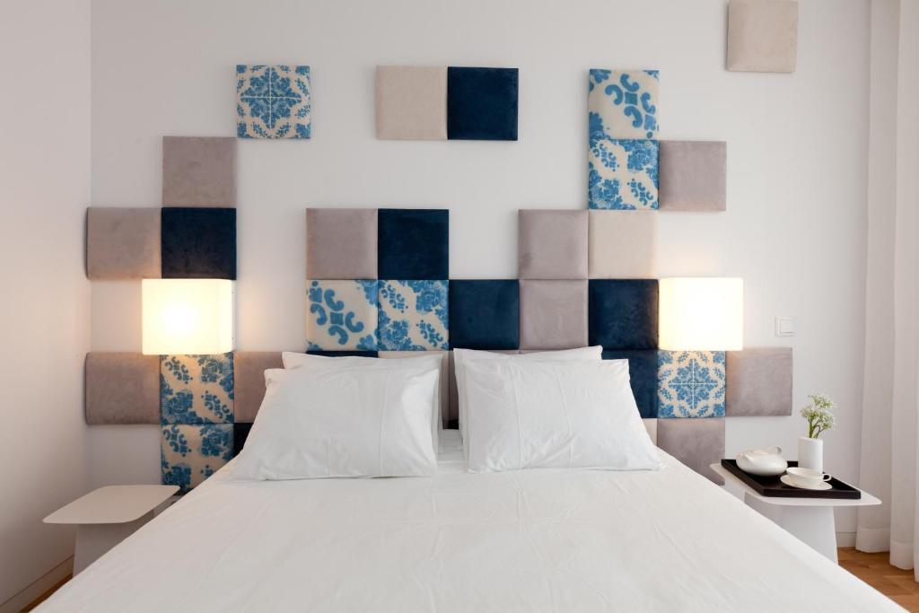 a bedroom with a white bed and blue and white walls at InPatio Guest House in Porto