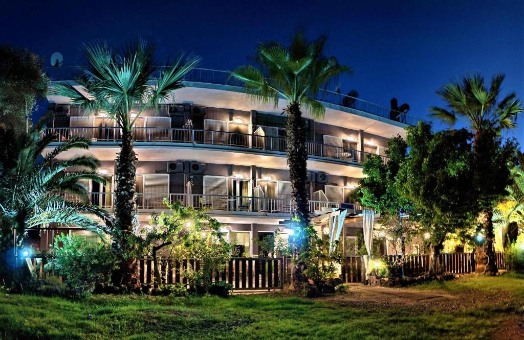 a building with palm trees in front of it at night at Galazio Asteri I in Loutrópolis Thermís