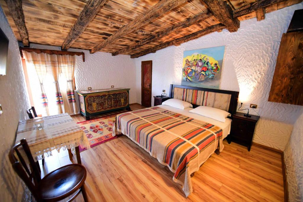 a bedroom with a bed and a desk in it at Hotel Tradita in Shkodër