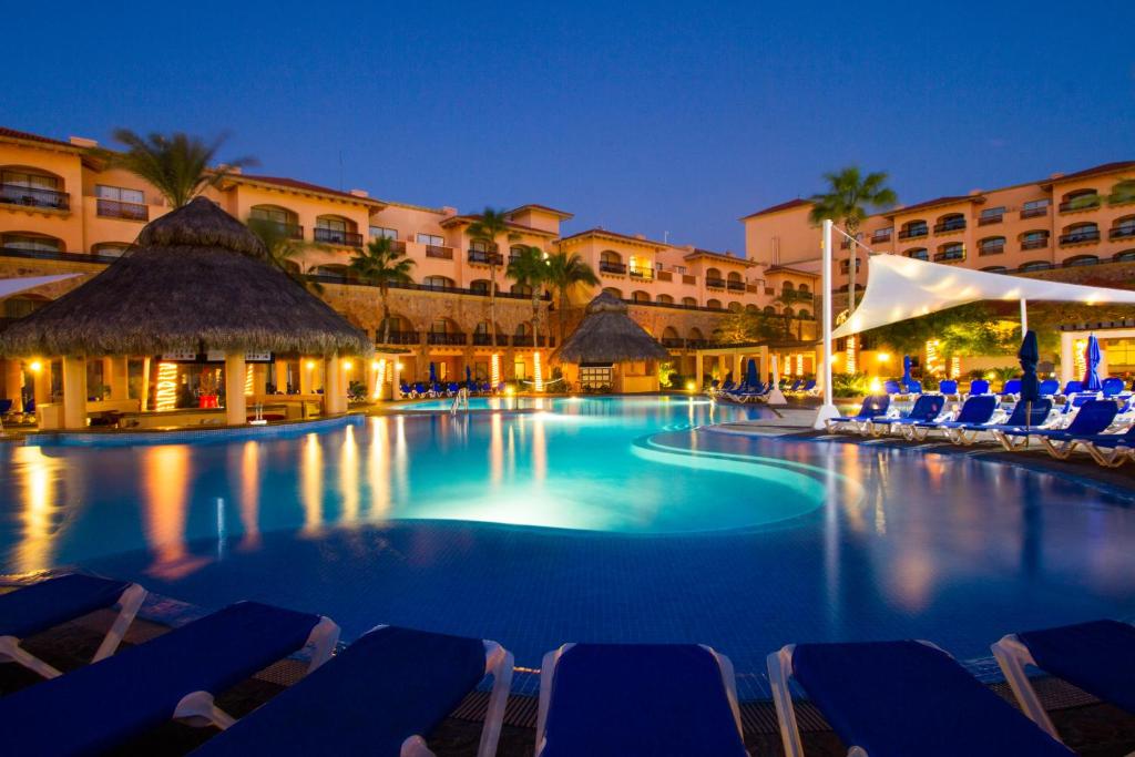 a swimming pool at night with chairs and buildings at Royal Solaris Los Cabos-All Inclusive in San José del Cabo