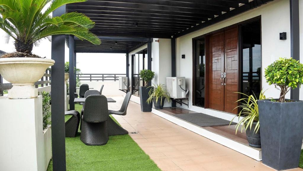 um quarto com um pátio com cadeiras e plantas em Sebastien Hotel em Mactan