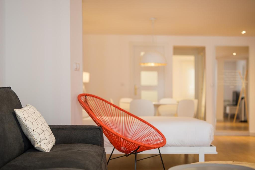 een woonkamer met een bank en een stoel bij Apartamento SoMbrereria RiMboMbin in Burgos