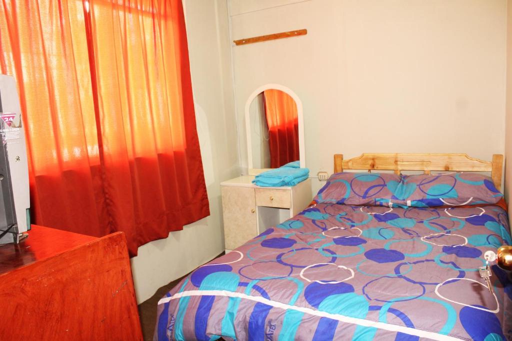 1 dormitorio con cama y cortina roja en Hostel Climbing Point, en Huaraz