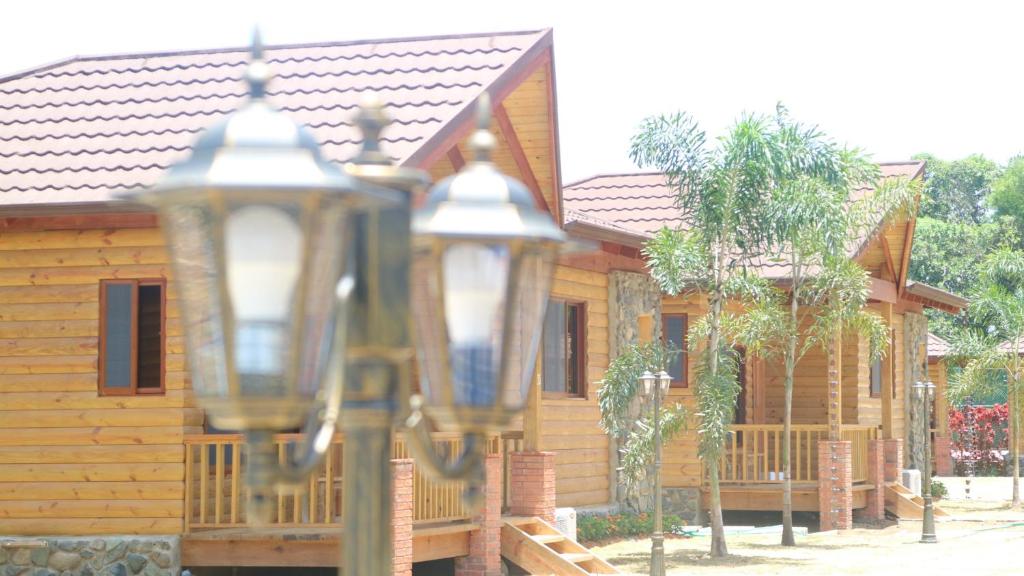 a wooden house with two lights in front of it at Carmen Hotel & Villas in Jarabacoa