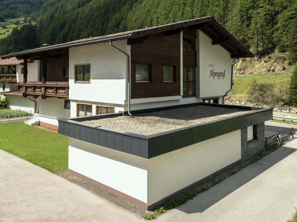 une maison avec une terrasse couverte et un toit dans l'établissement Haus Alpengruß, à Sölden