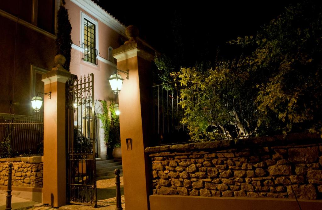 a house with a stone wall and a gate at night at La Meridiana Relais in Formello