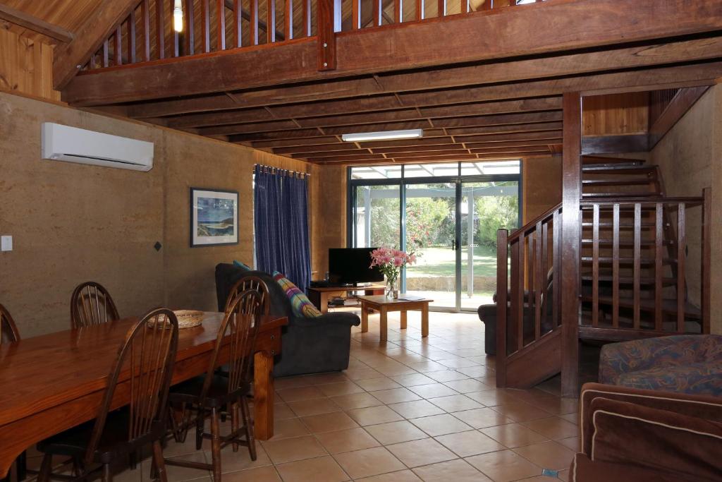 a living room with a wooden table and a couch at Margaret River Seascape in Margaret River Town
