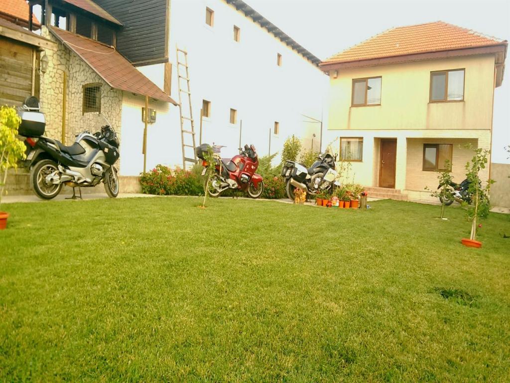 a group of motorcycles parked in a yard next to a house at Casa Noastra in Vama Veche