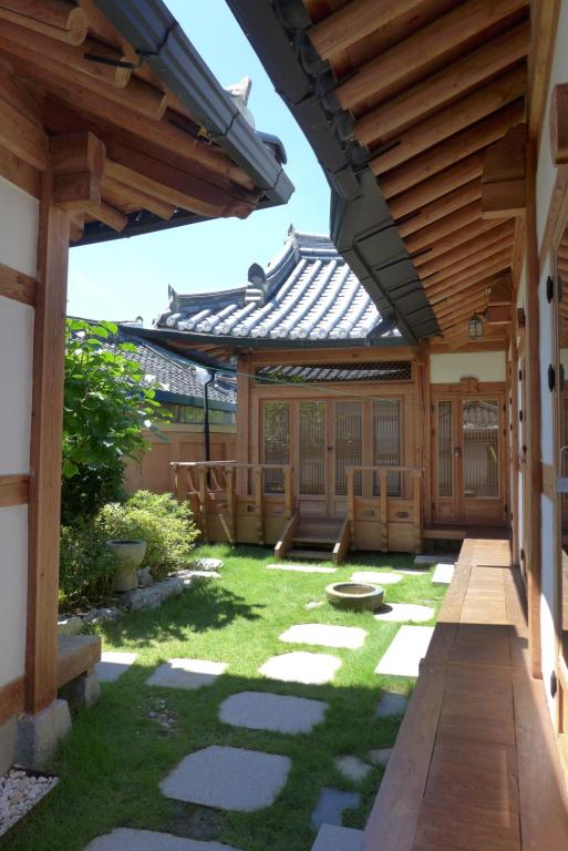 an outdoor patio with a wooden pergola at Sarangroo in Jeonju